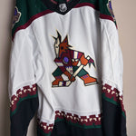 Brand New  Size: 60G   100% polyester  Officially licensed by the NHL  Made by Adidas  Relaxed Fit  Crewneck  Arizona Coyotes Crest  White/Green/Black/Burgundy   Steal at this price!  No refund if tag is removed